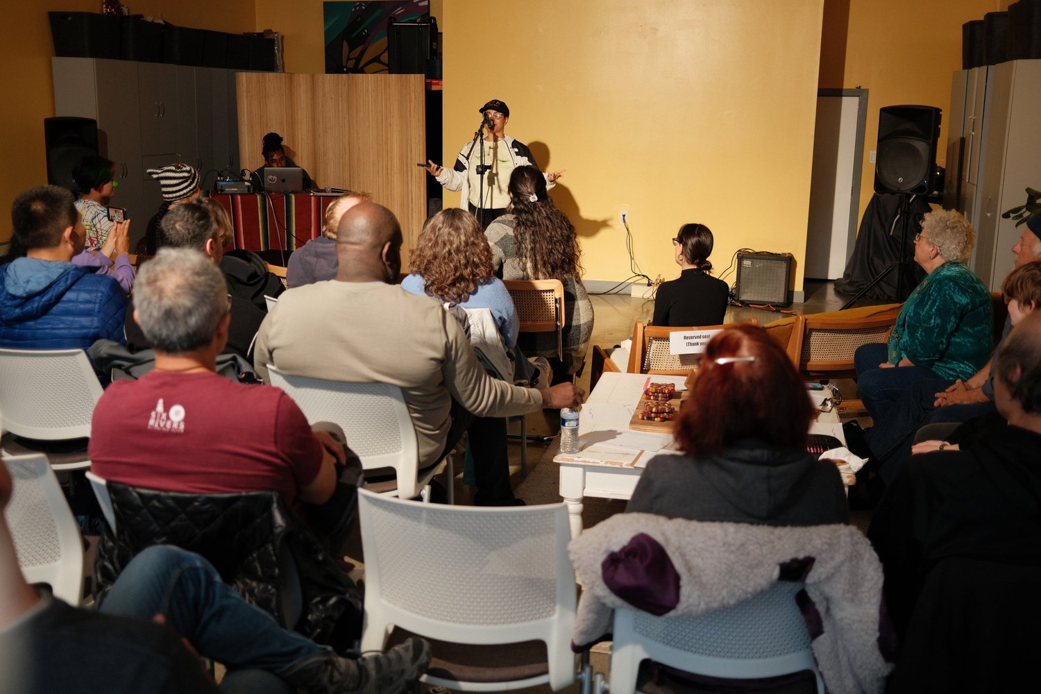 Open-mic performer standing beside the sound table.
