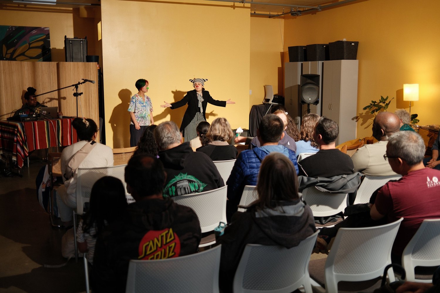 Two participants presenting together, one extending both arms.