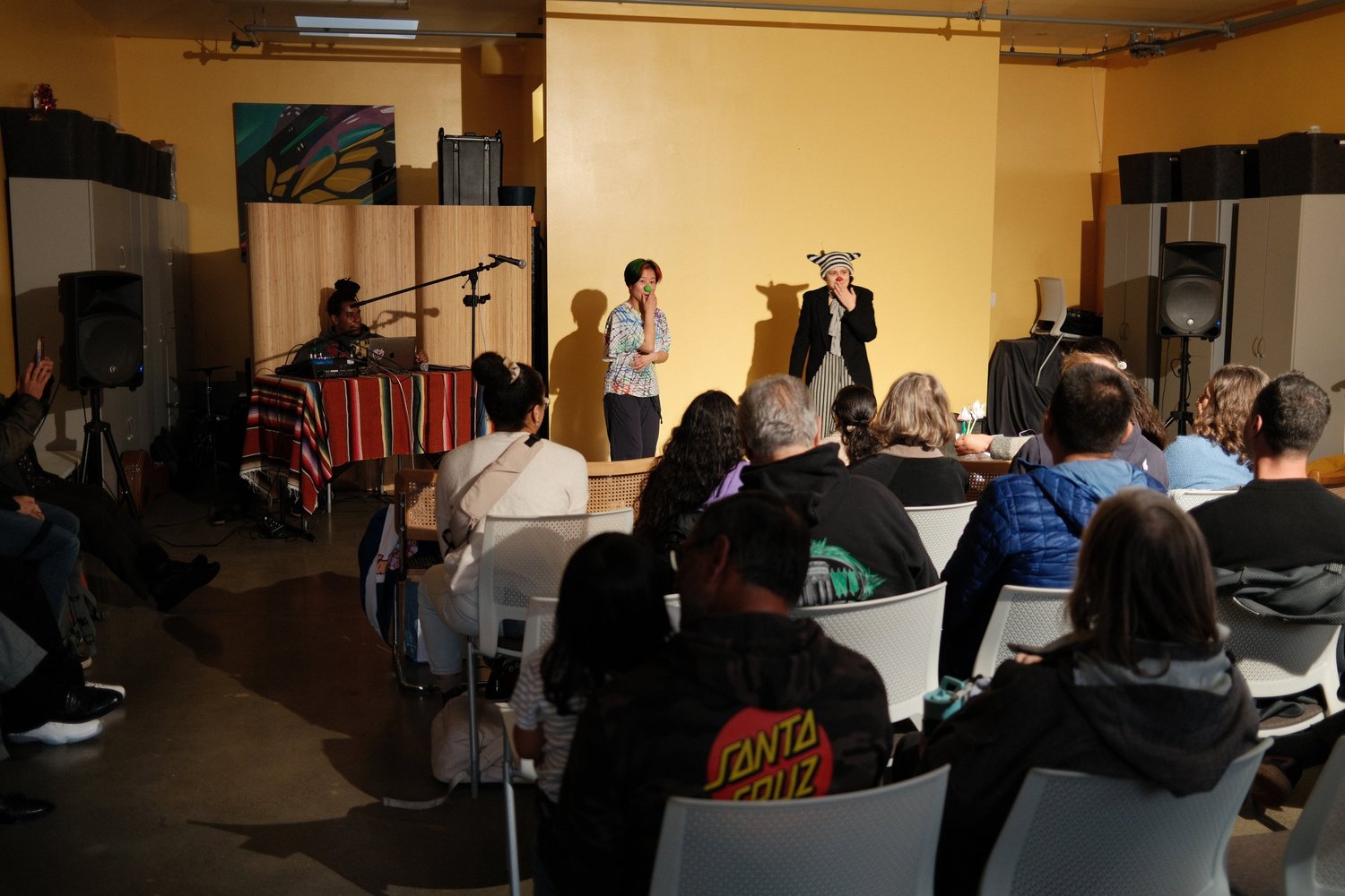 Presenter in a dark outfit gesturing beside another participant.