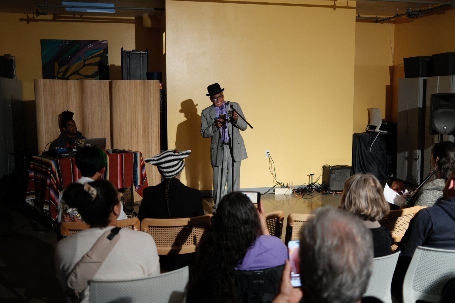 Closer view of a performer in a striped jacket and brimmed hat.