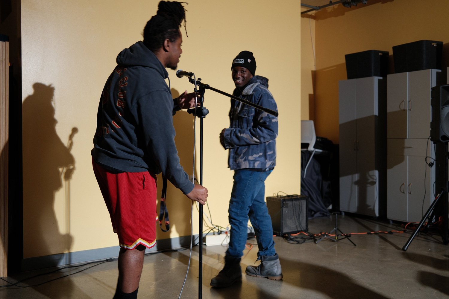 Two participants adjusting a microphone stand.