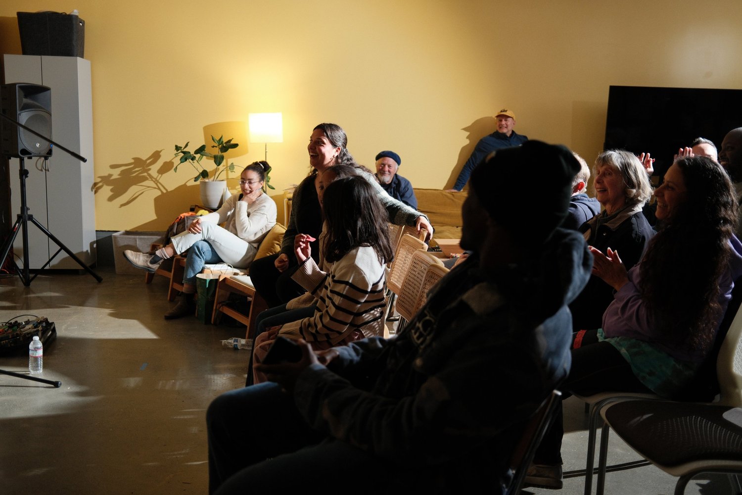 Attendees watching from chairs along the side wall.