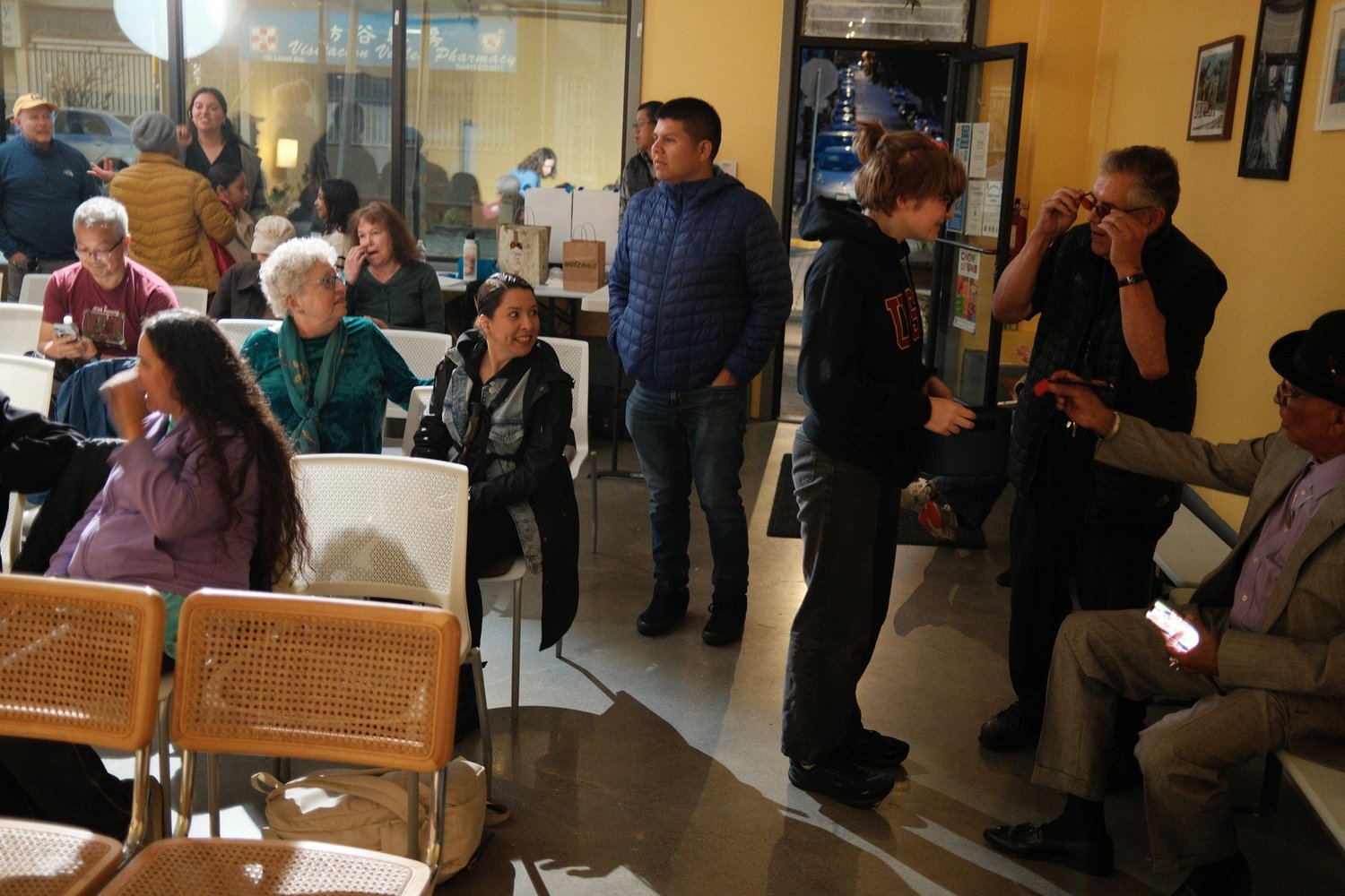 Attendees chatting between rows of chairs.