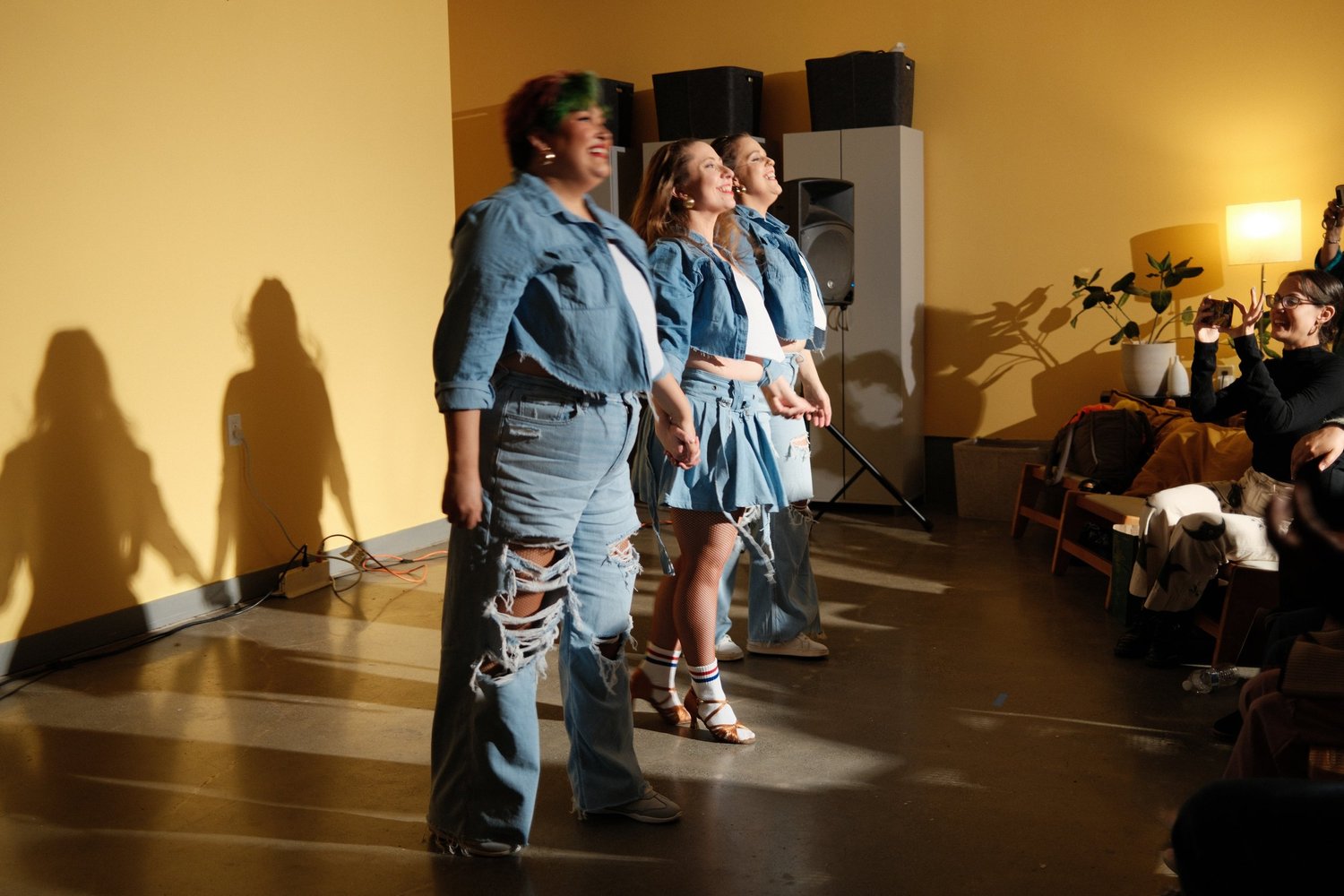 Three performers standing together at the end of a dance.