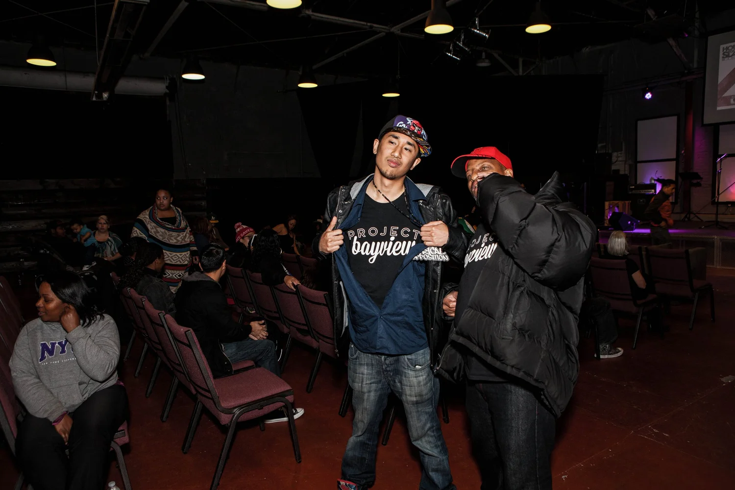 Two participants posing in front of the seated audience.
