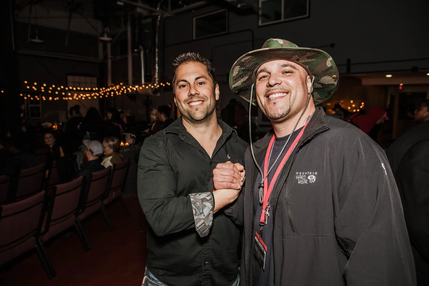 Two smiling participants clasping hands.