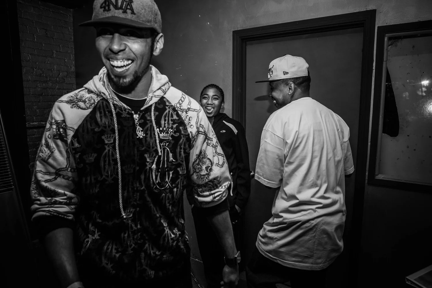 Black-and-white portrait of a smiling attendee in a cap.
