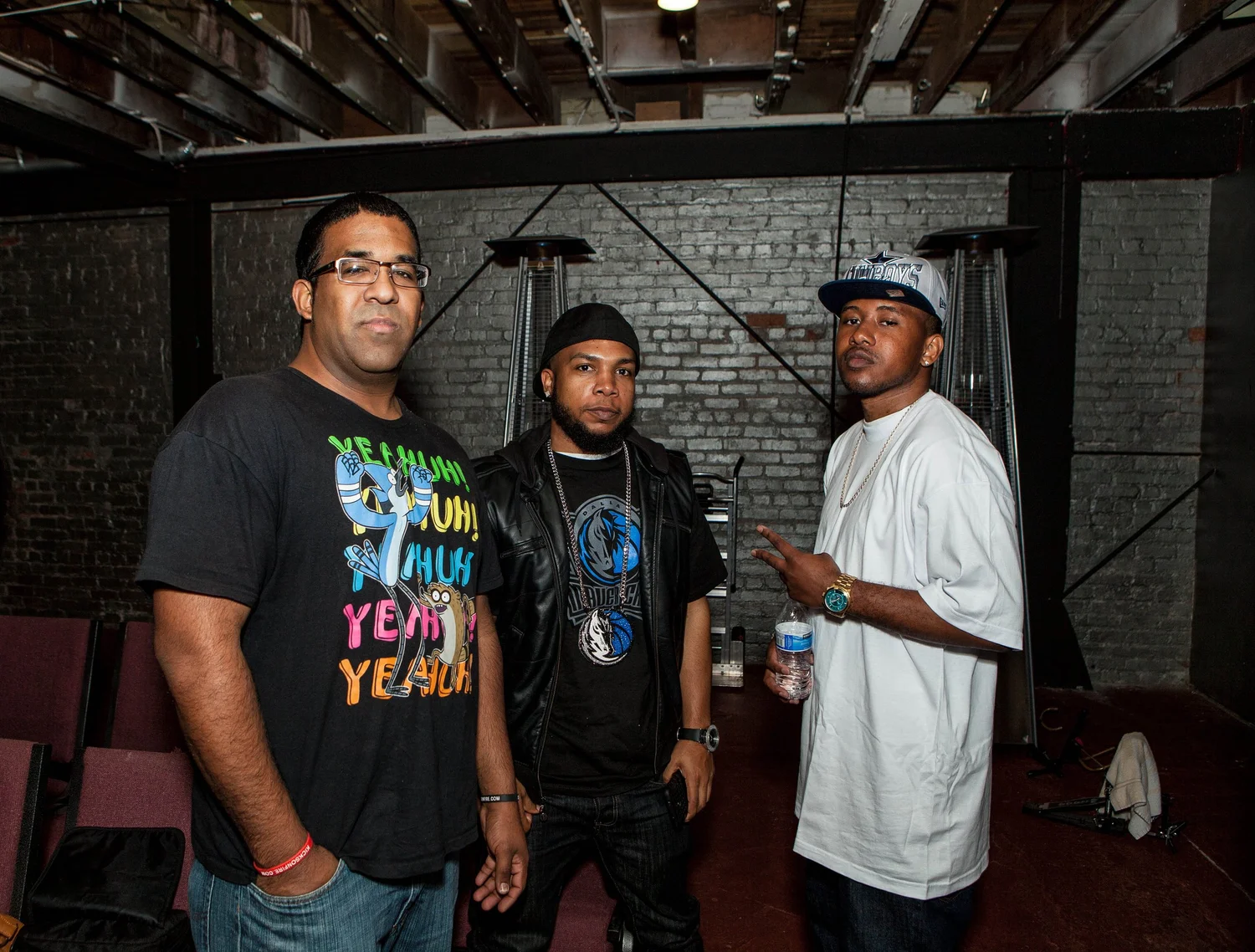 Three participants posing together near the stage.