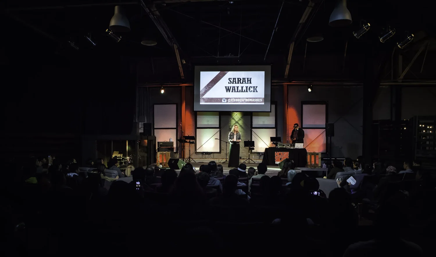 Wide view from the back of the venue toward the illuminated stage.