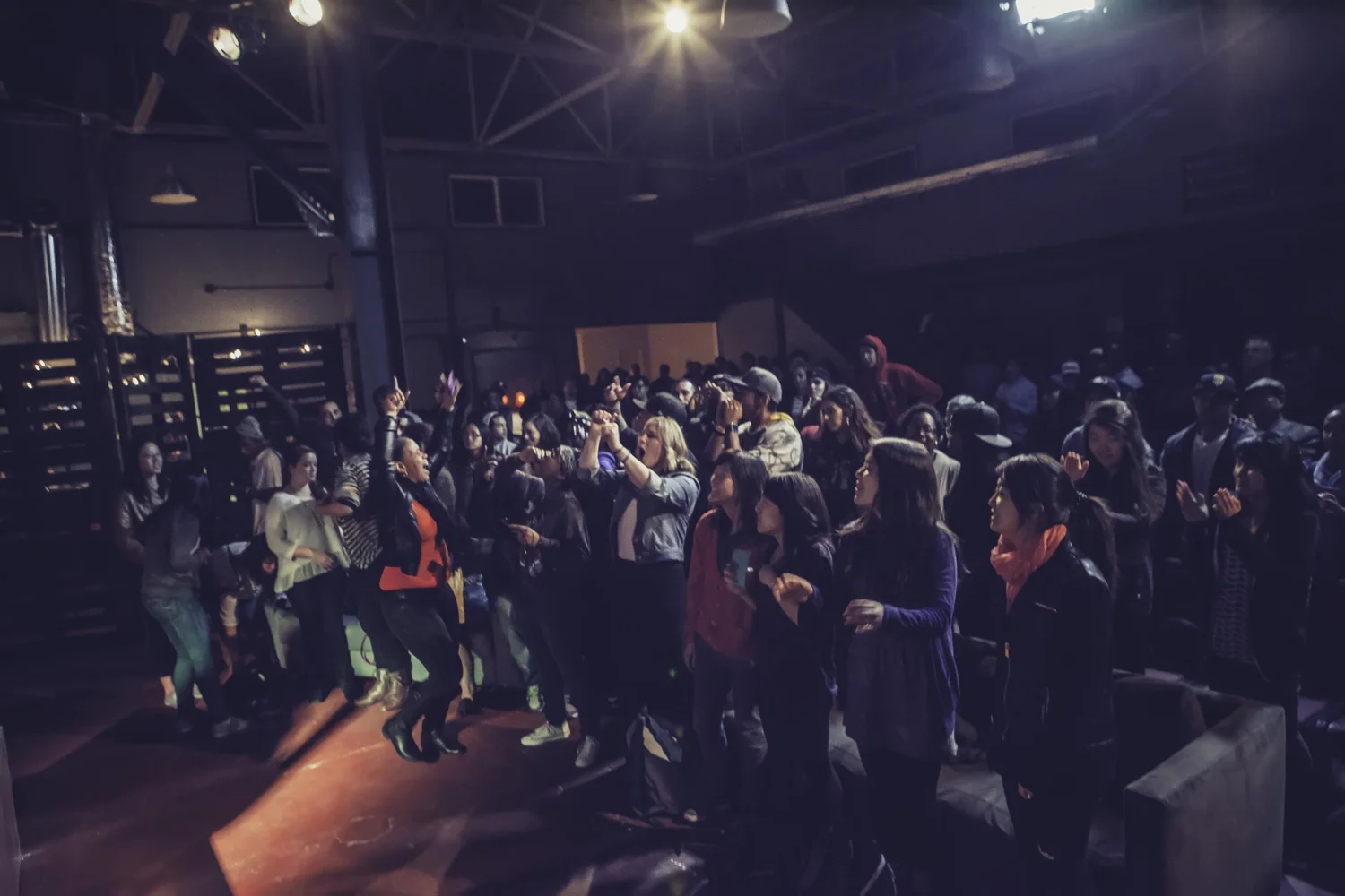 Crowd raising hands toward the stage.