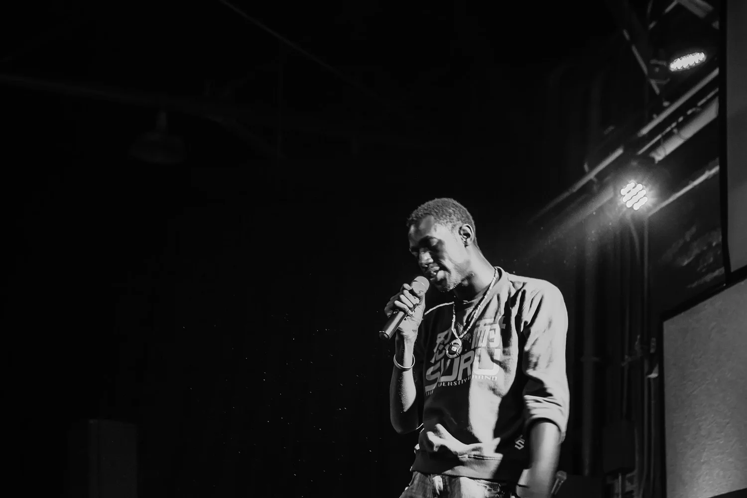 Black-and-white close view of a vocalist holding a microphone.