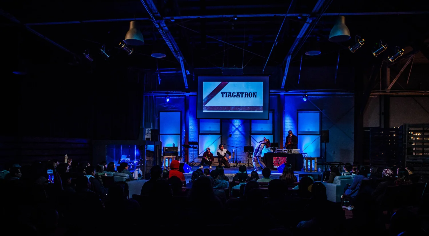 Wide view of the blue-lit stage and audience.