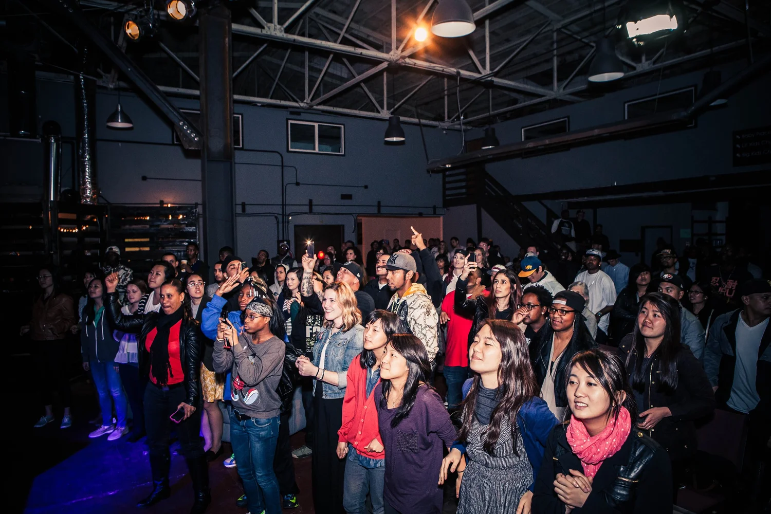 Audience smiling and gesturing toward the performers.
