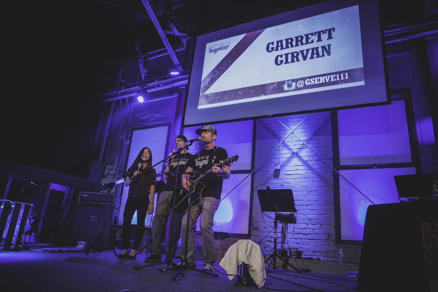 Performers beneath a Garrett Girvan projection.