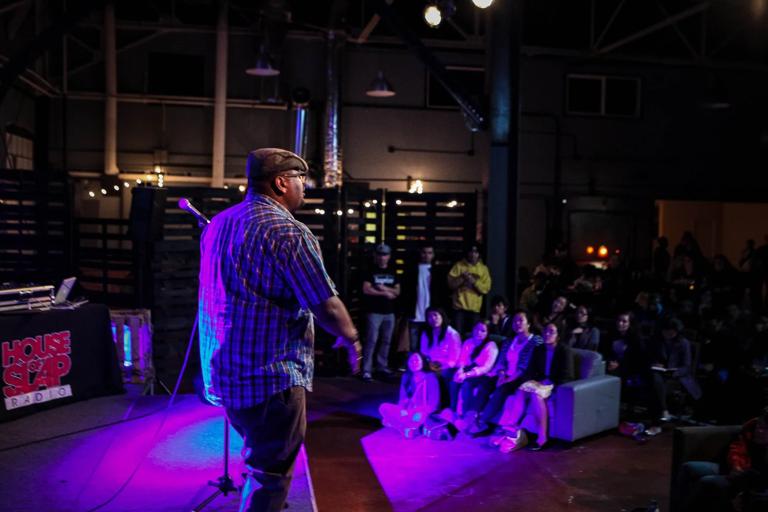 Performer addressing an audience seated close to the stage.