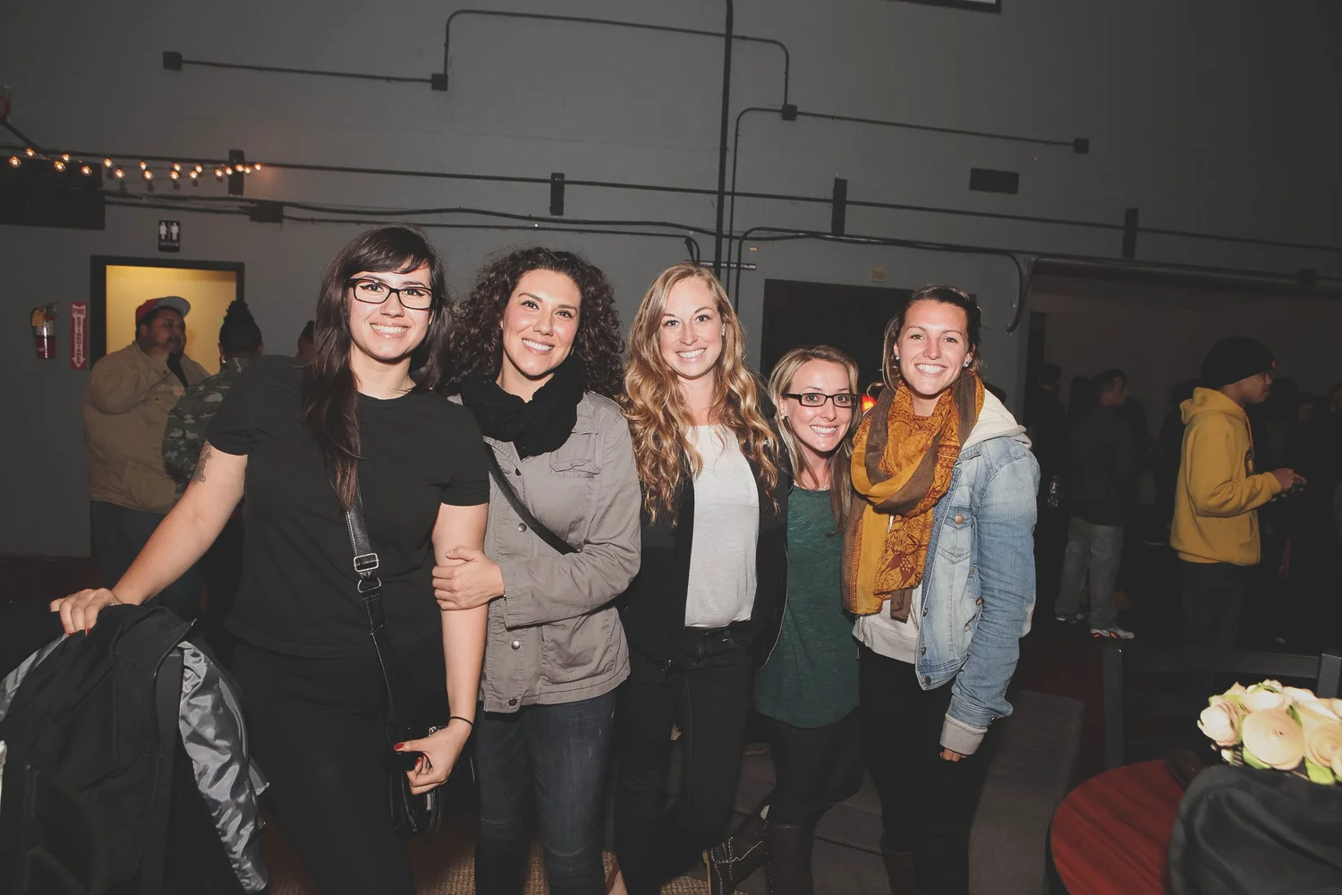 Five attendees posing together inside the venue.