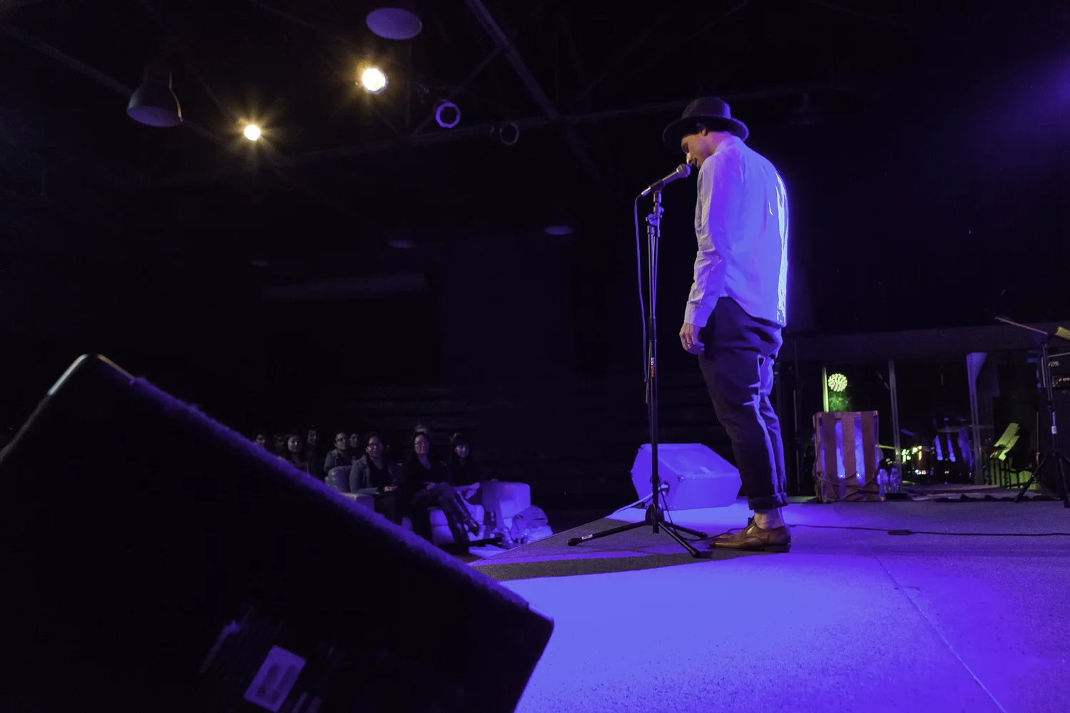 Side view of a performer beside a microphone stand.