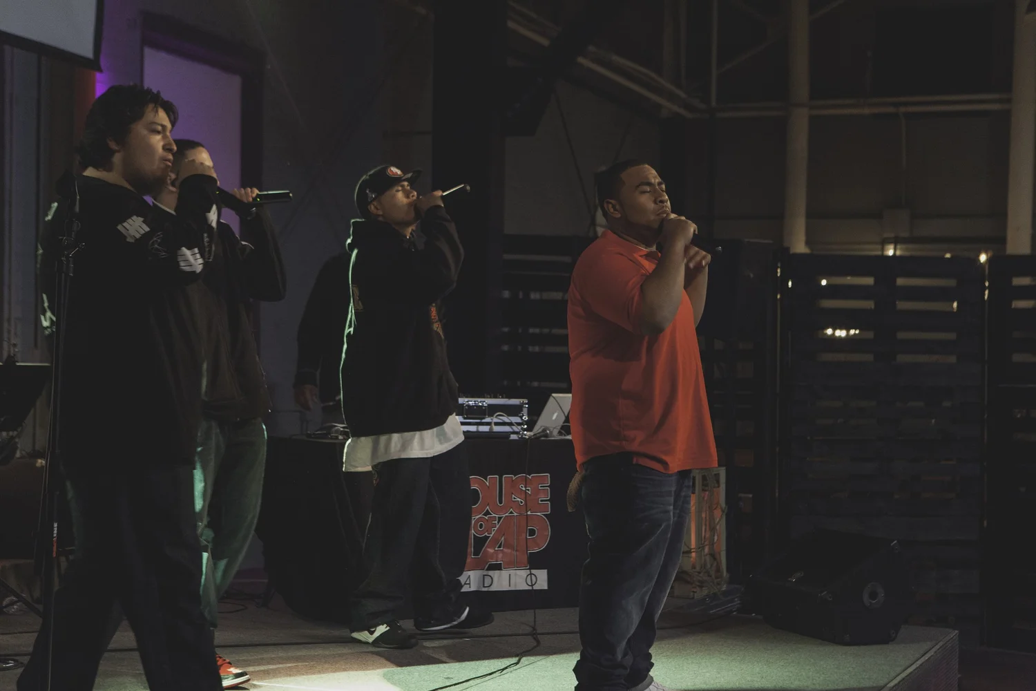 Three vocalists performing together.