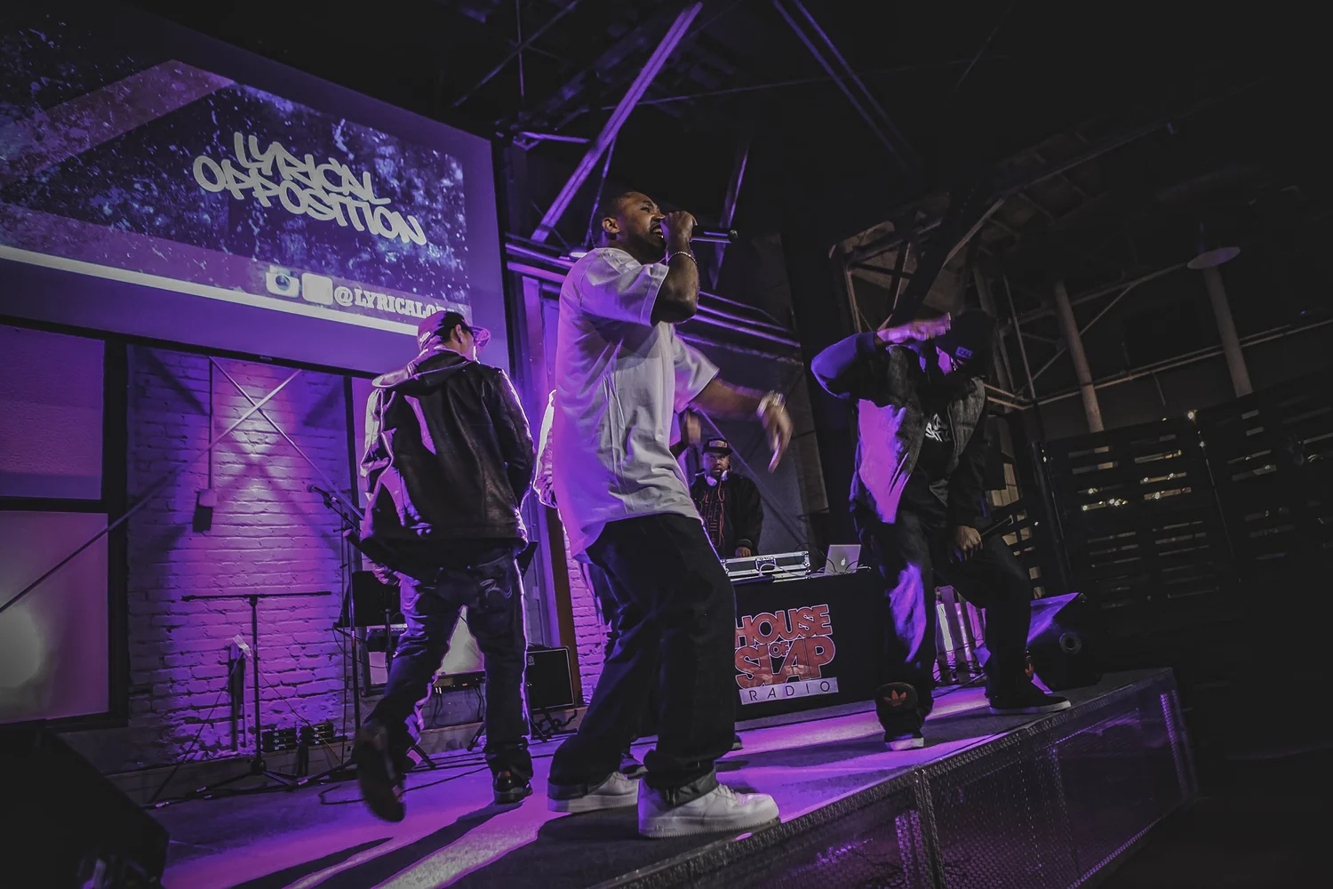 Group performing beneath the Lyrical Opposition logo.