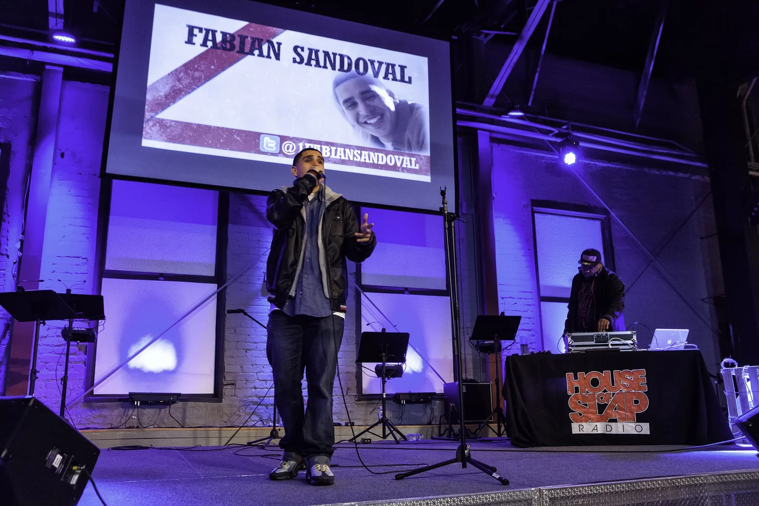 Vocalist performing beneath a Fabian Sandoval projection.