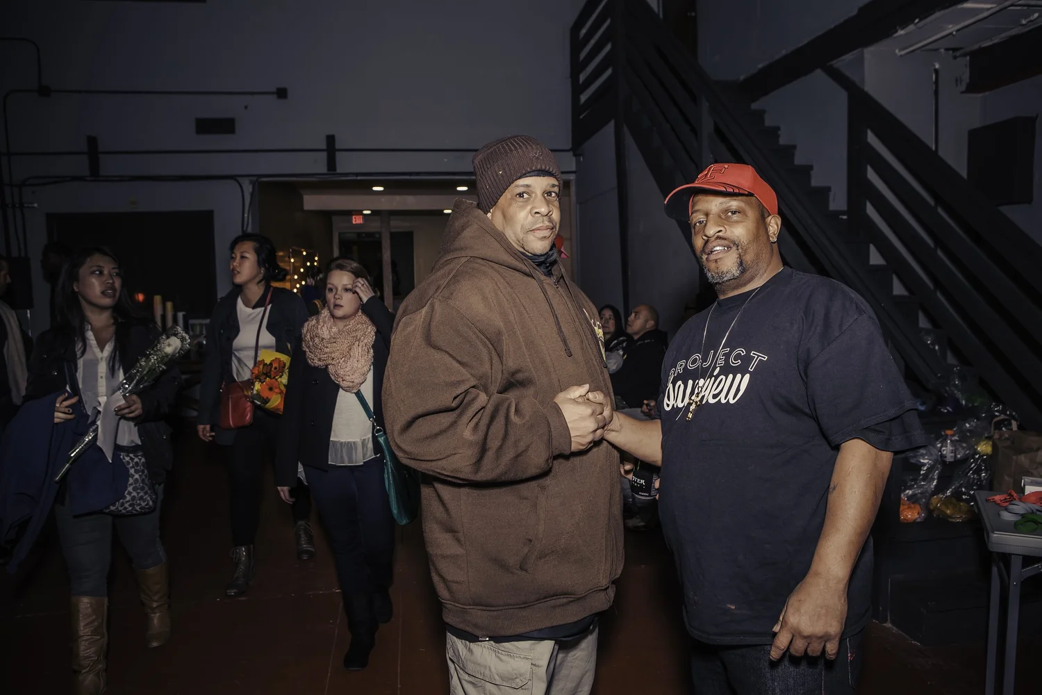Two smiling attendees clasping hands.