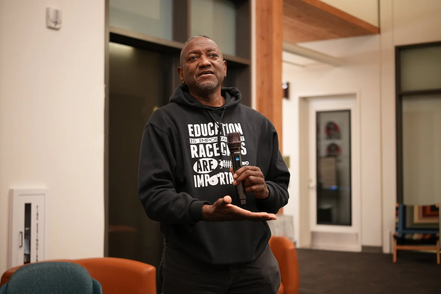 A performer speaks into a microphone during the community gathering.