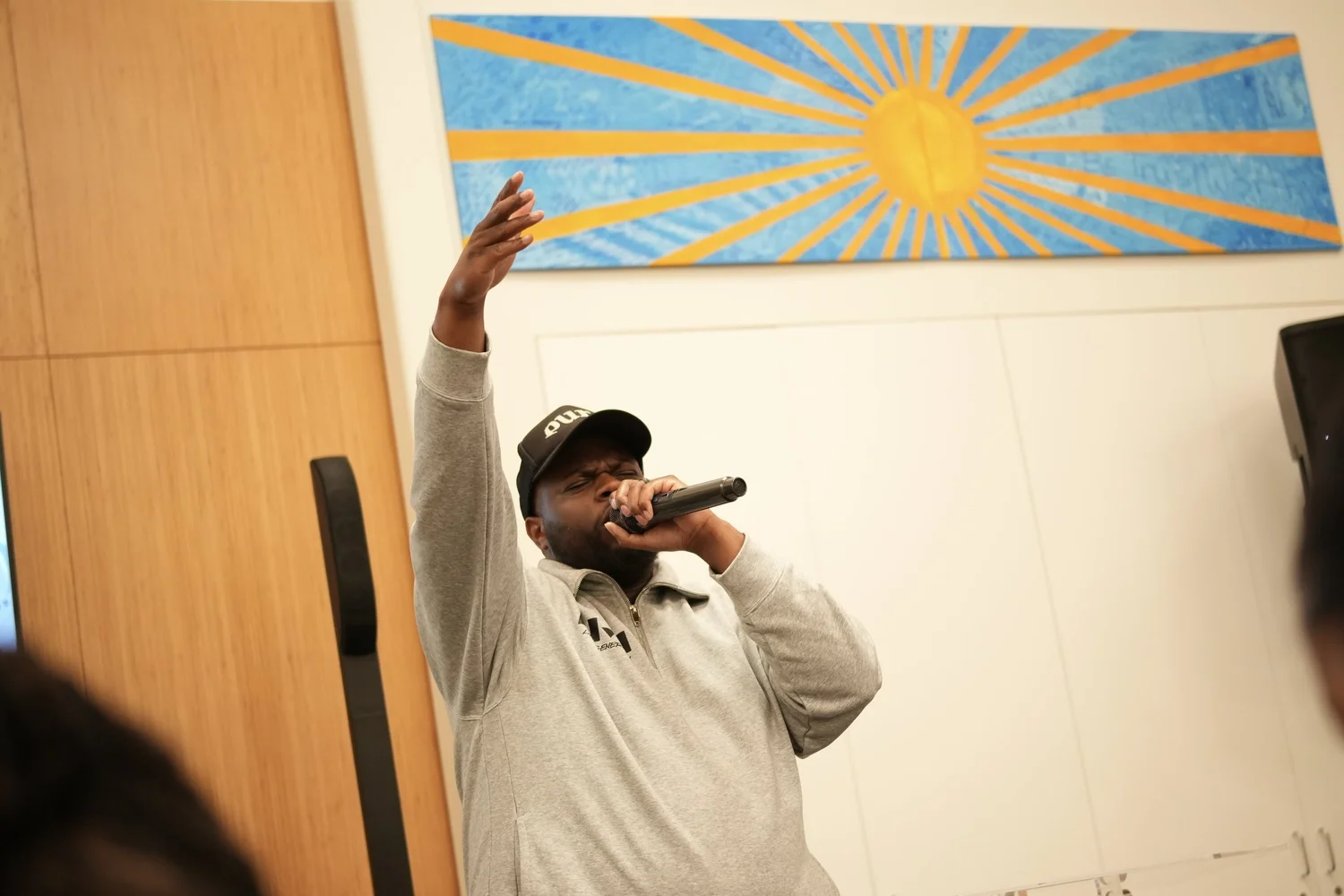 A performer speaks into a microphone during the community gathering.