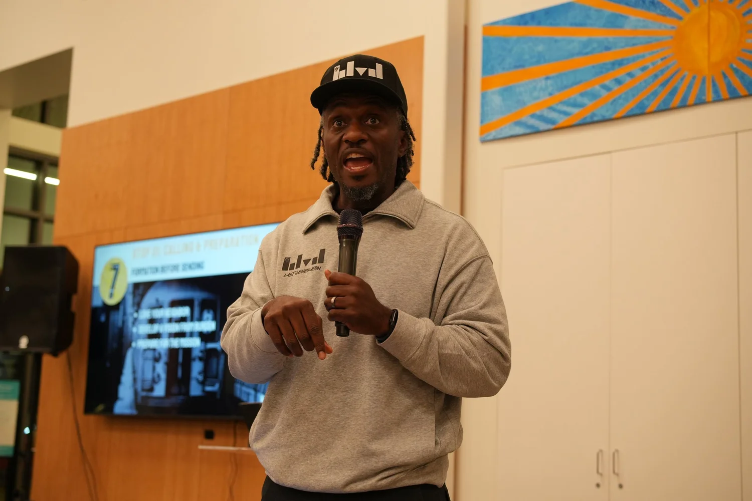 A performer speaks into a microphone during the community gathering.