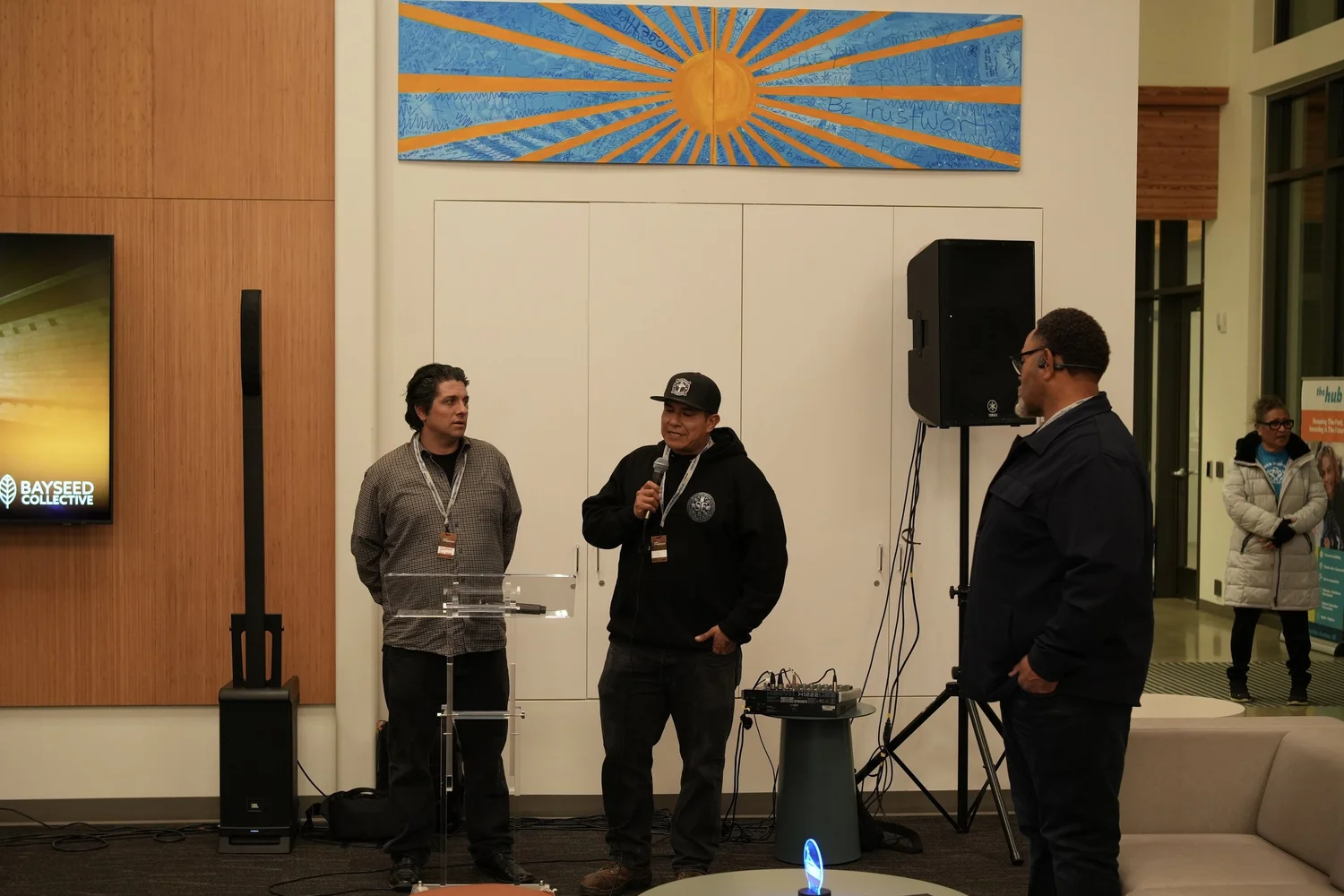 A performer speaks into a microphone during the community gathering.