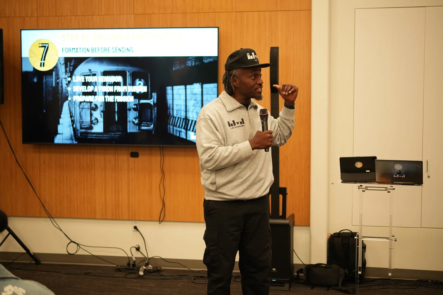 A performer speaks into a microphone during the community gathering.