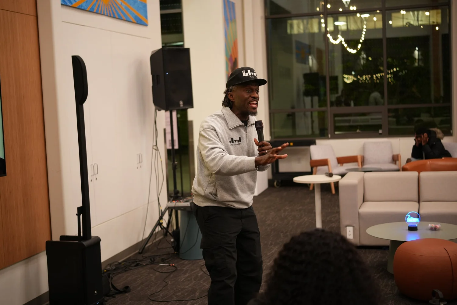 A performer speaks into a microphone during the community gathering.