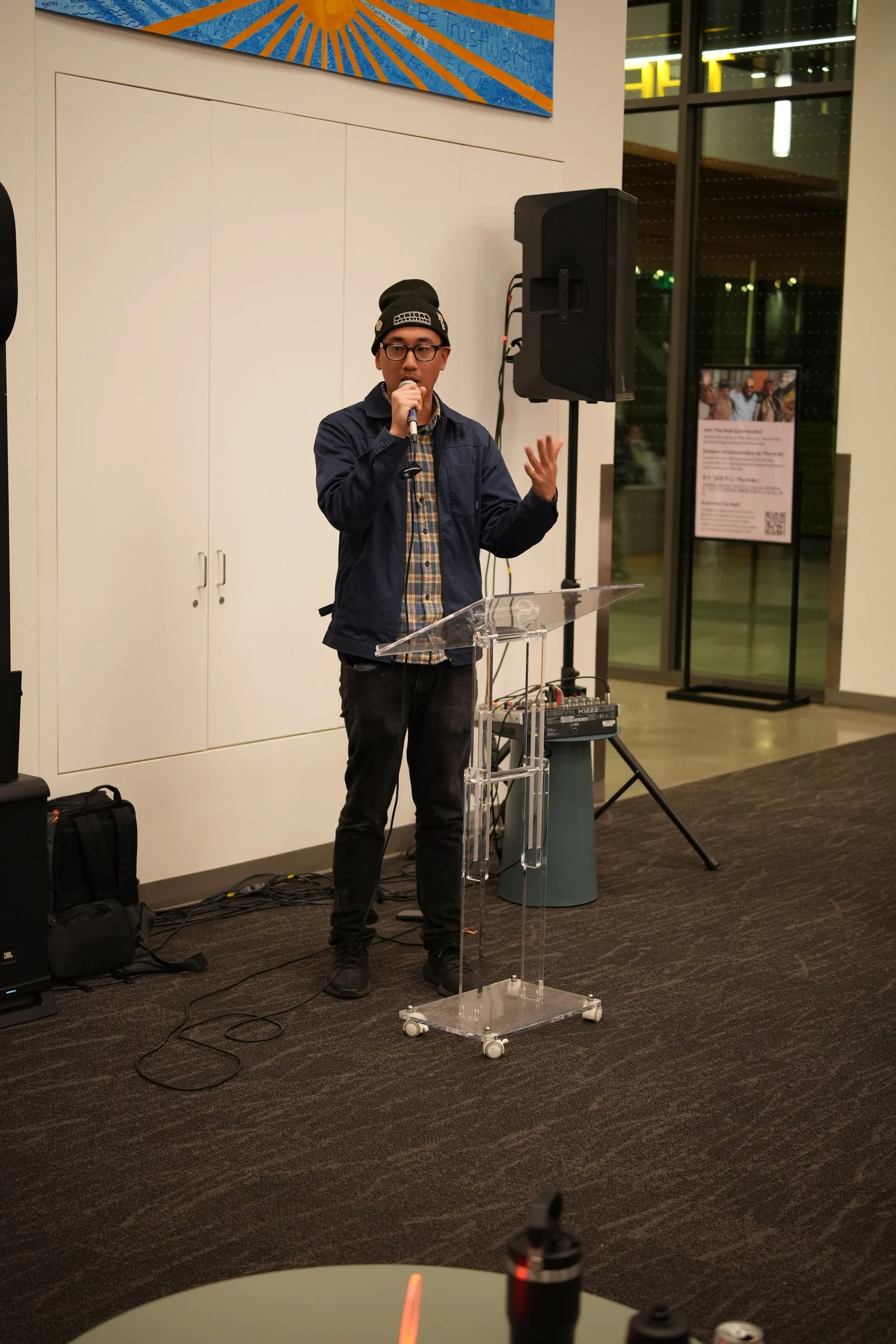 A performer speaks into a microphone during the community gathering.