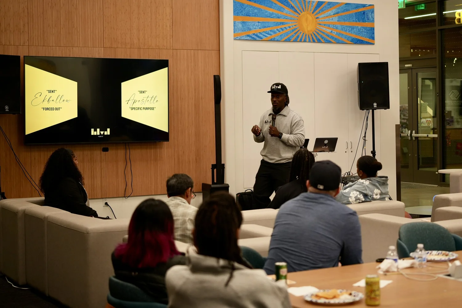 A performer speaks into a microphone during the community gathering.