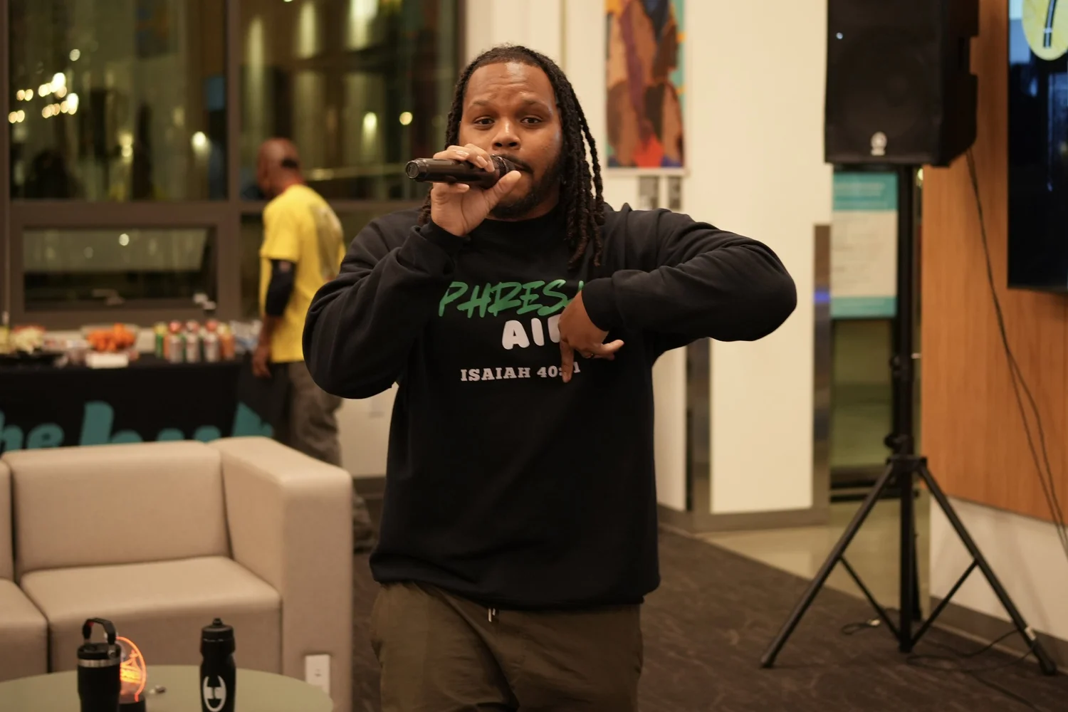 A performer speaks into a microphone during the community gathering.