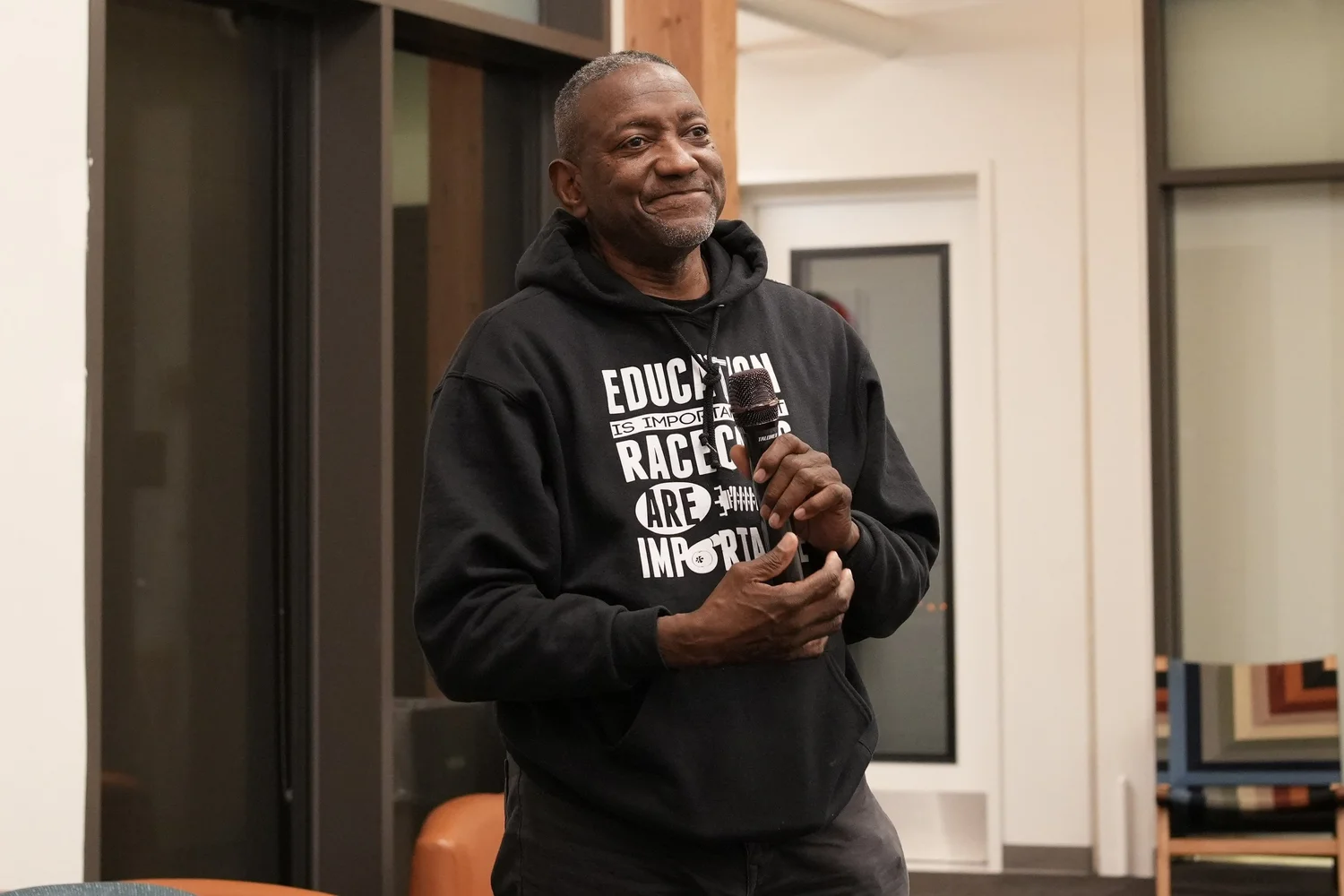 A performer speaks into a microphone during the community gathering.
