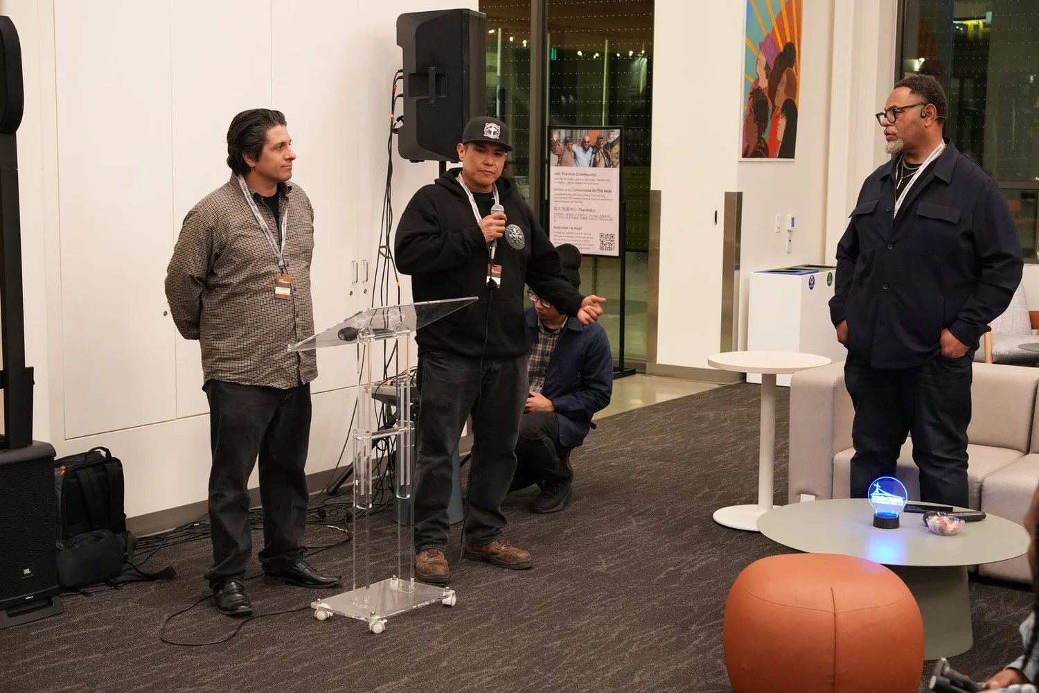 A performer speaks into a microphone during the community gathering.