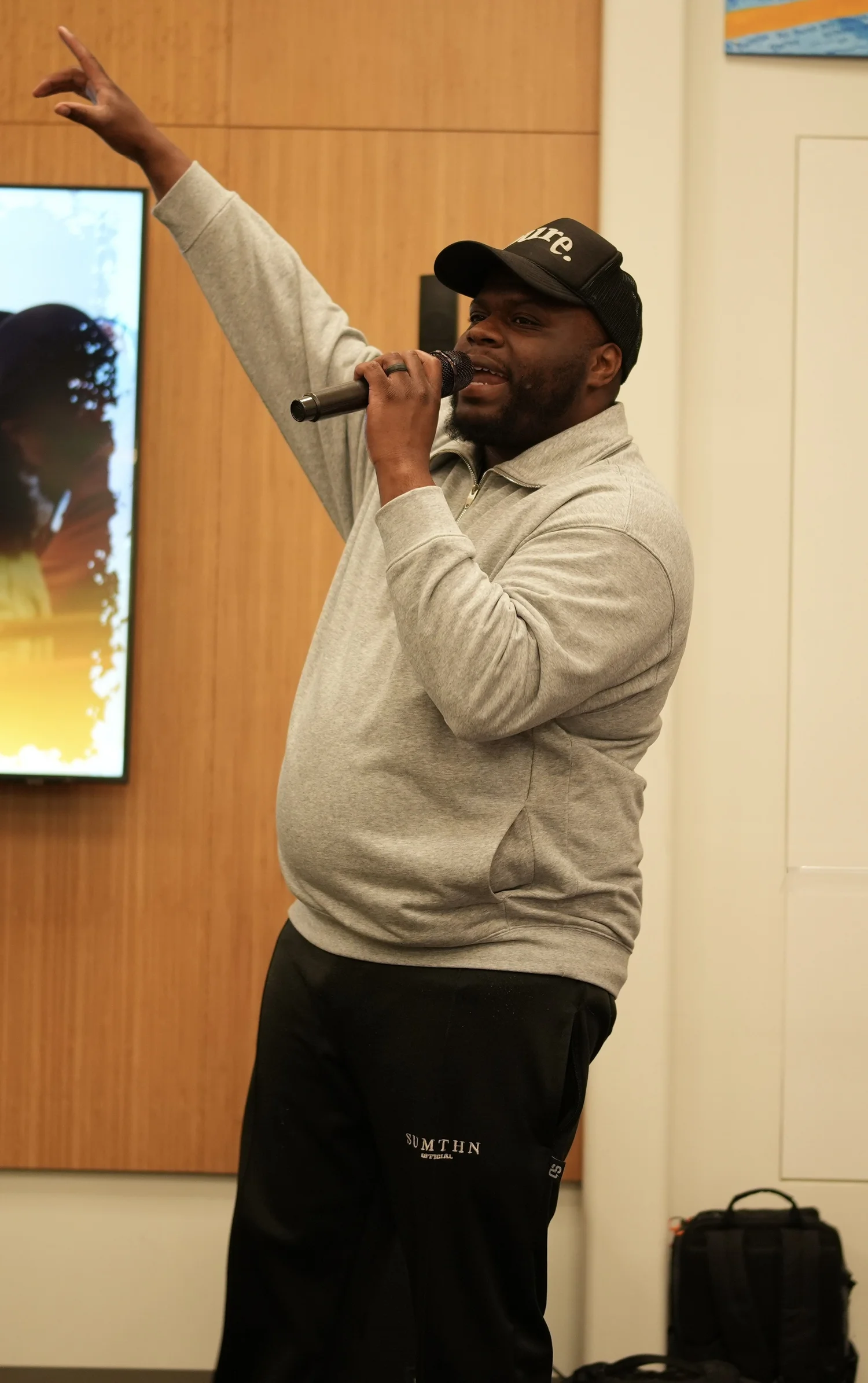 A performer speaks into a microphone during the community gathering.