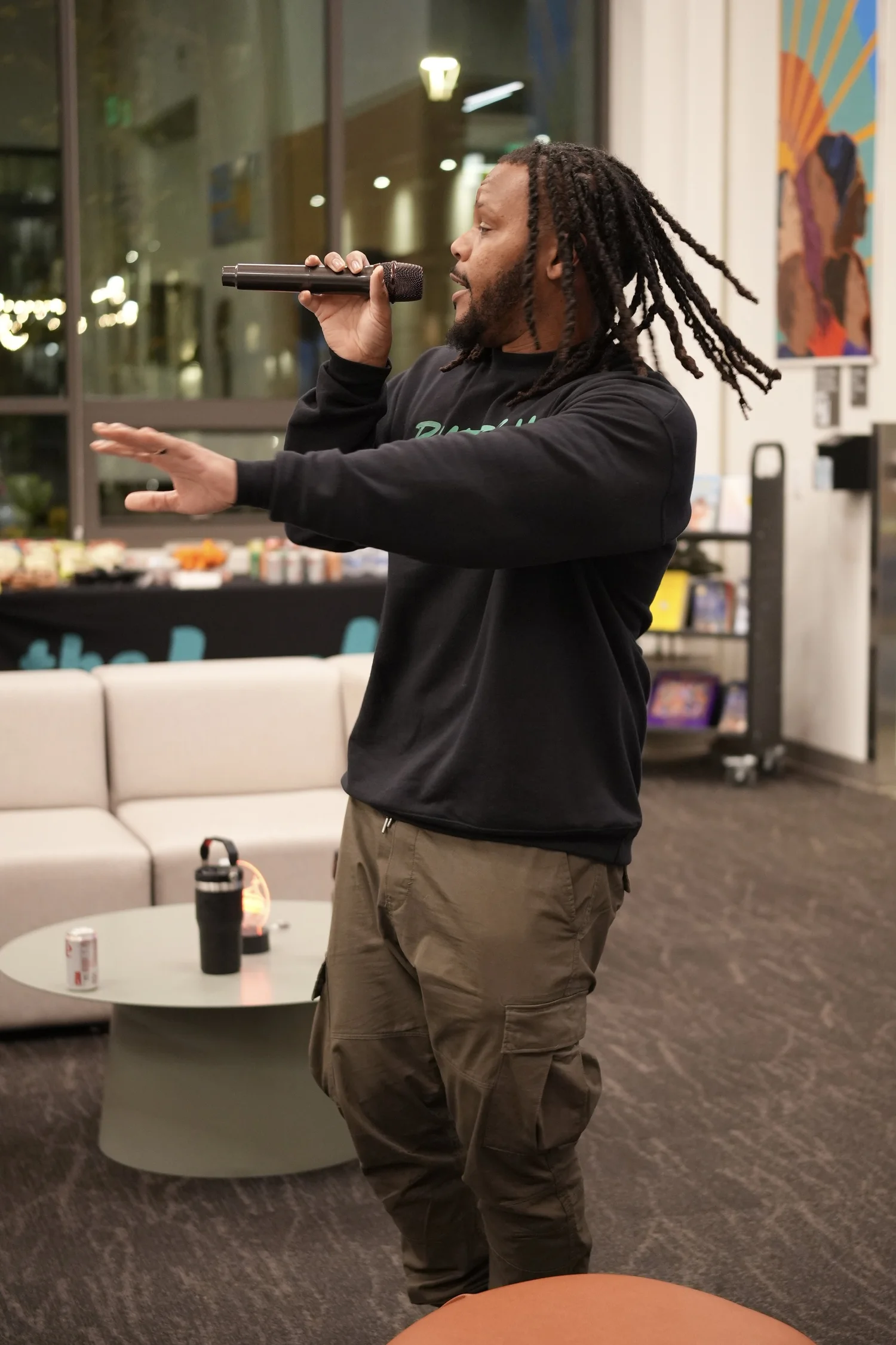 A performer speaks into a microphone during the community gathering.