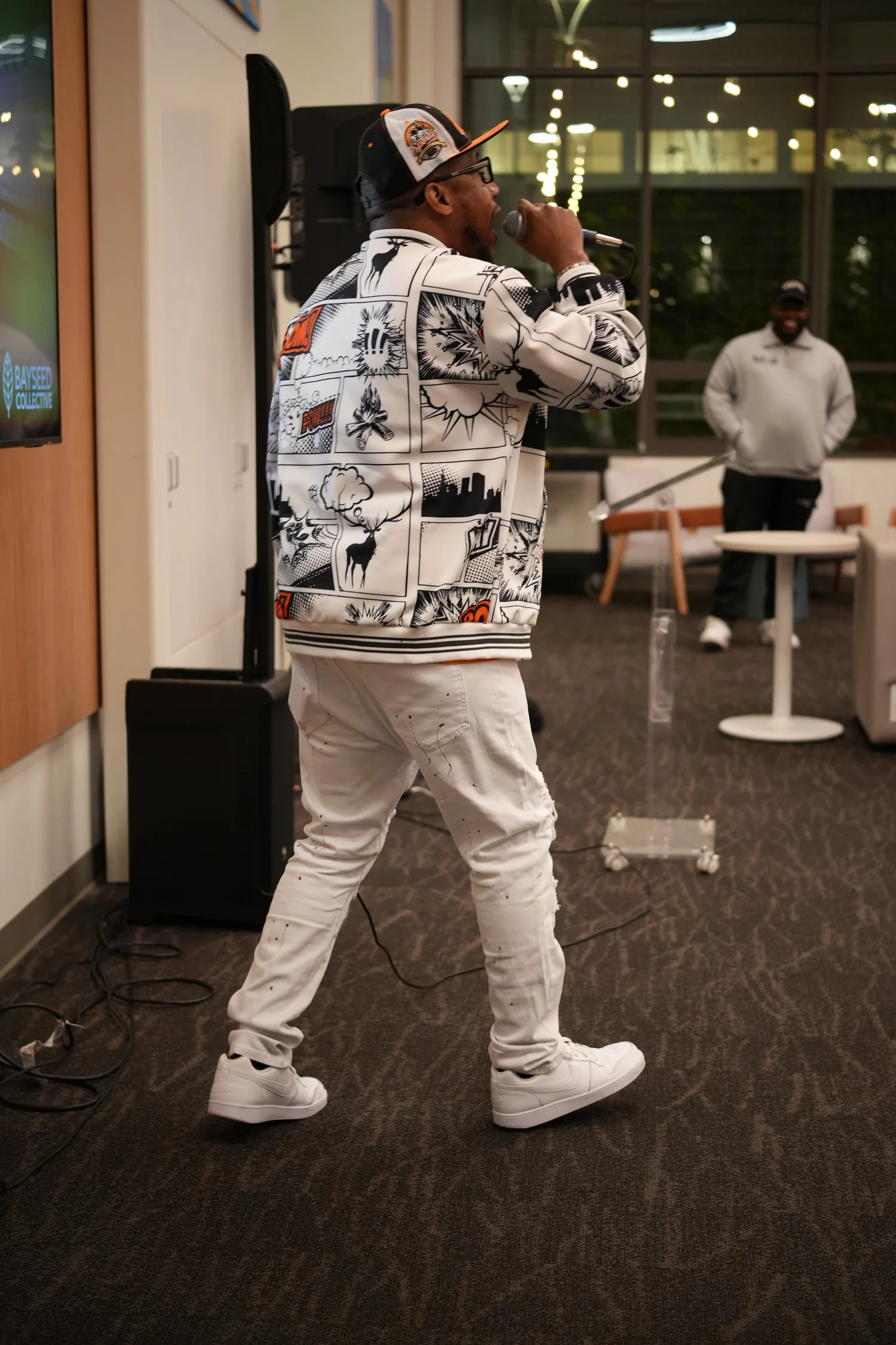 A performer speaks into a microphone during the community gathering.