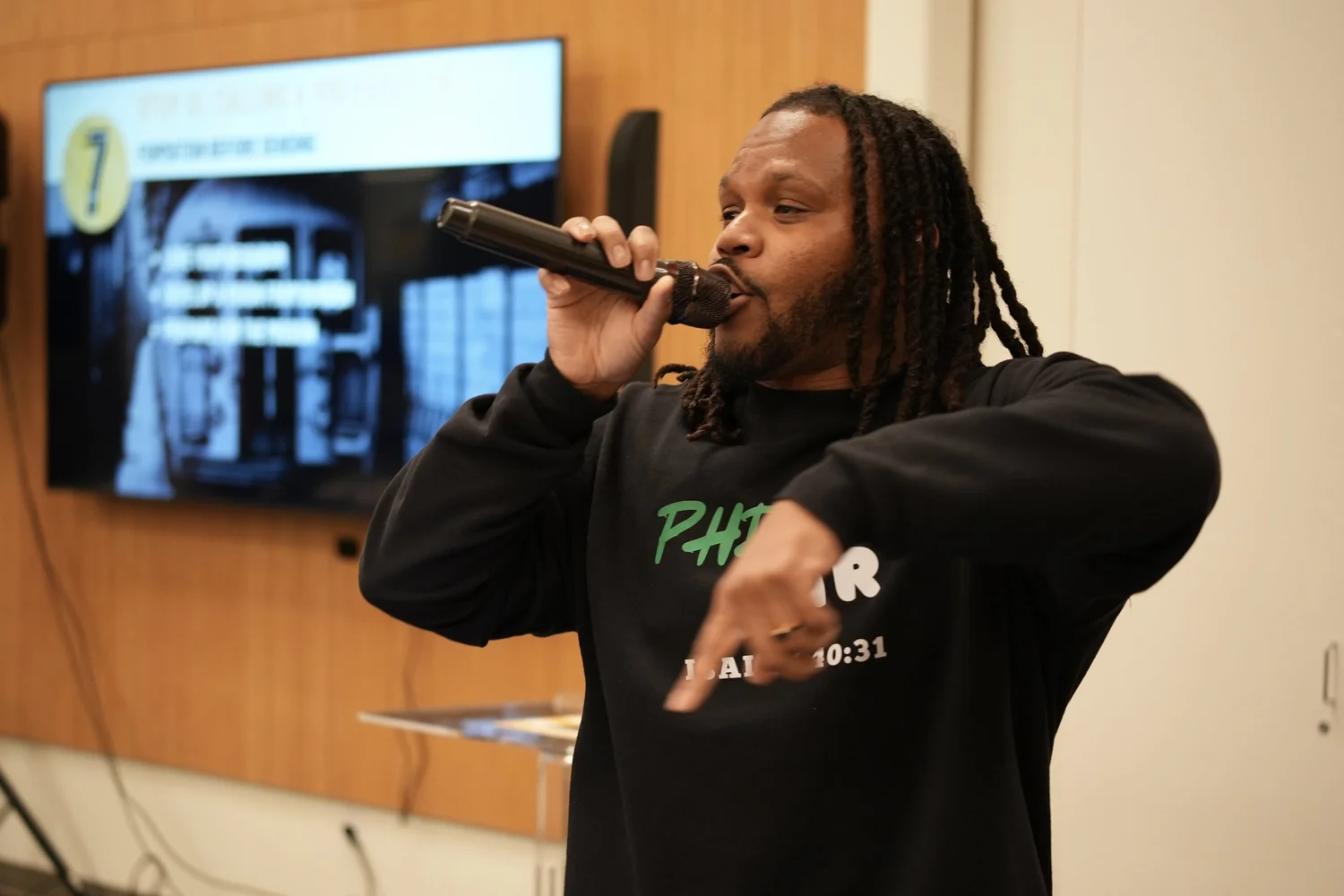 Performer with long hair rapping into a handheld microphone.