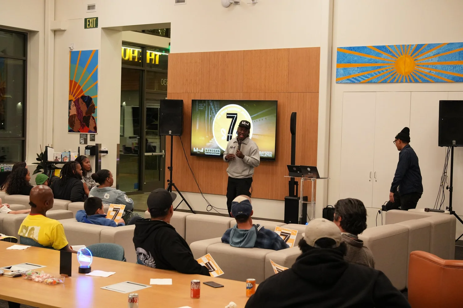 A performer speaks into a microphone during the community gathering.