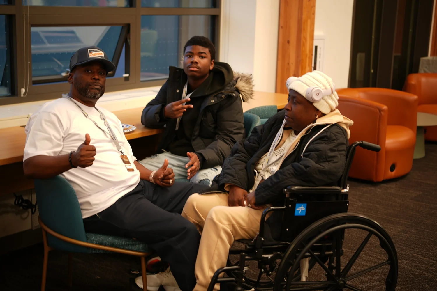 Three attendees talking, including a person using a wheelchair.