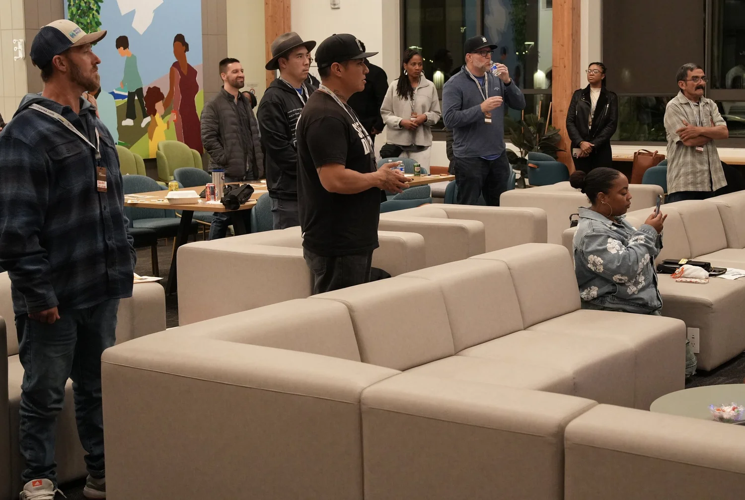 Attendees standing among lounge sofas during the gathering.