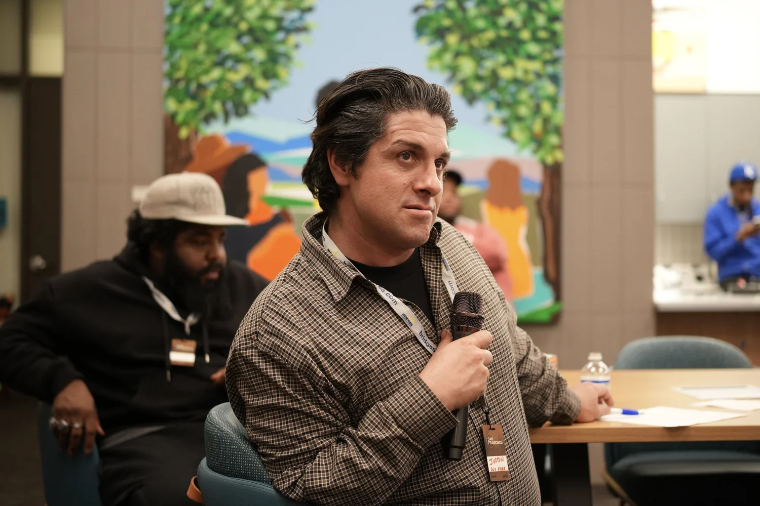 Speaker in a checked jacket holding a microphone.