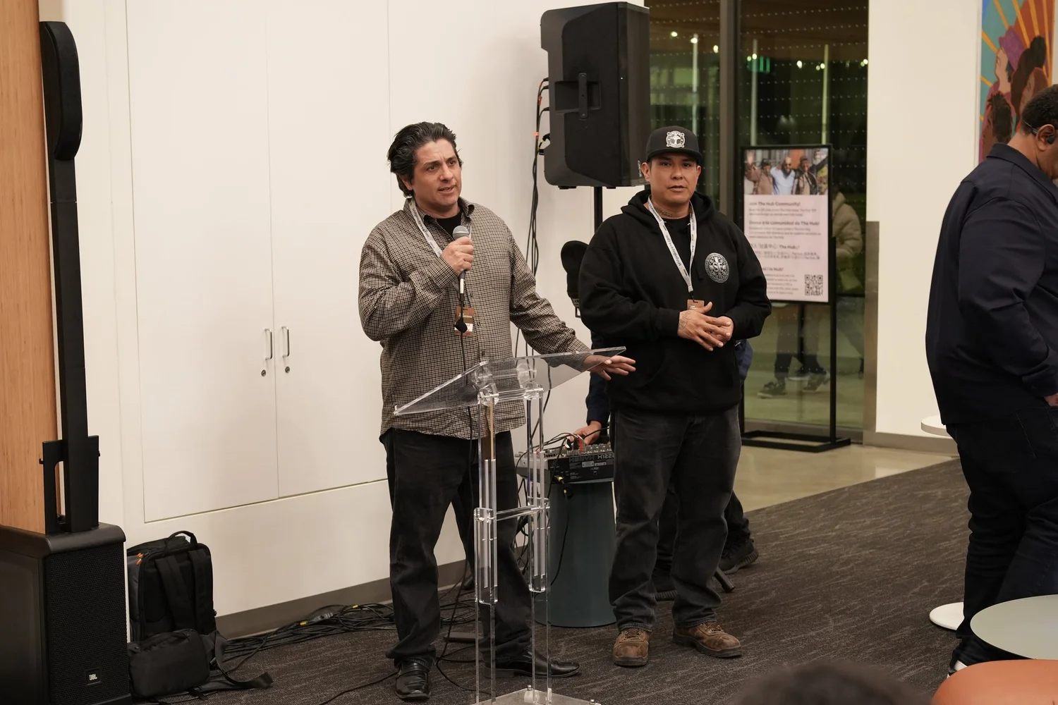 Two speakers standing together beside the lectern.