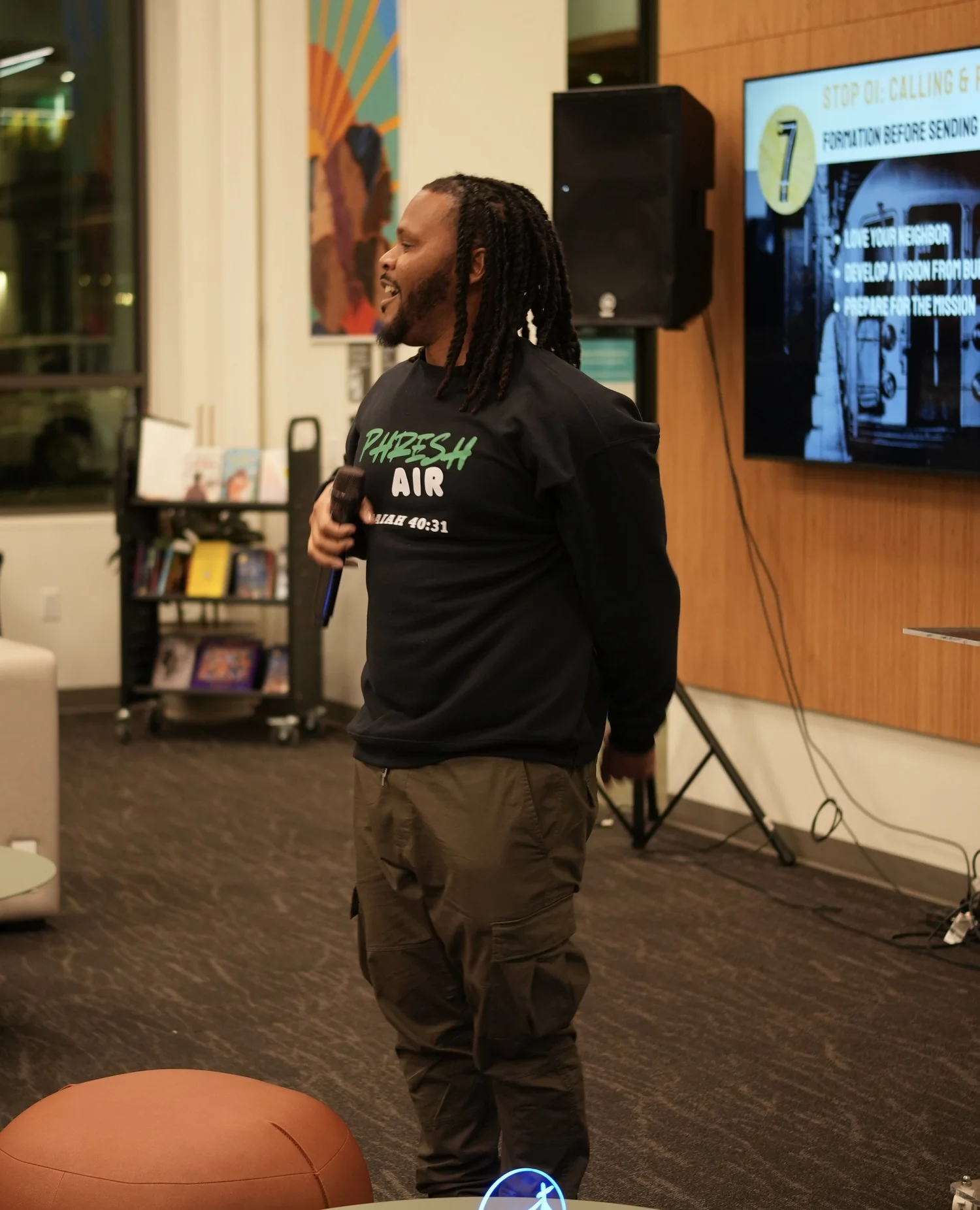 A performer speaks into a microphone during the community gathering.