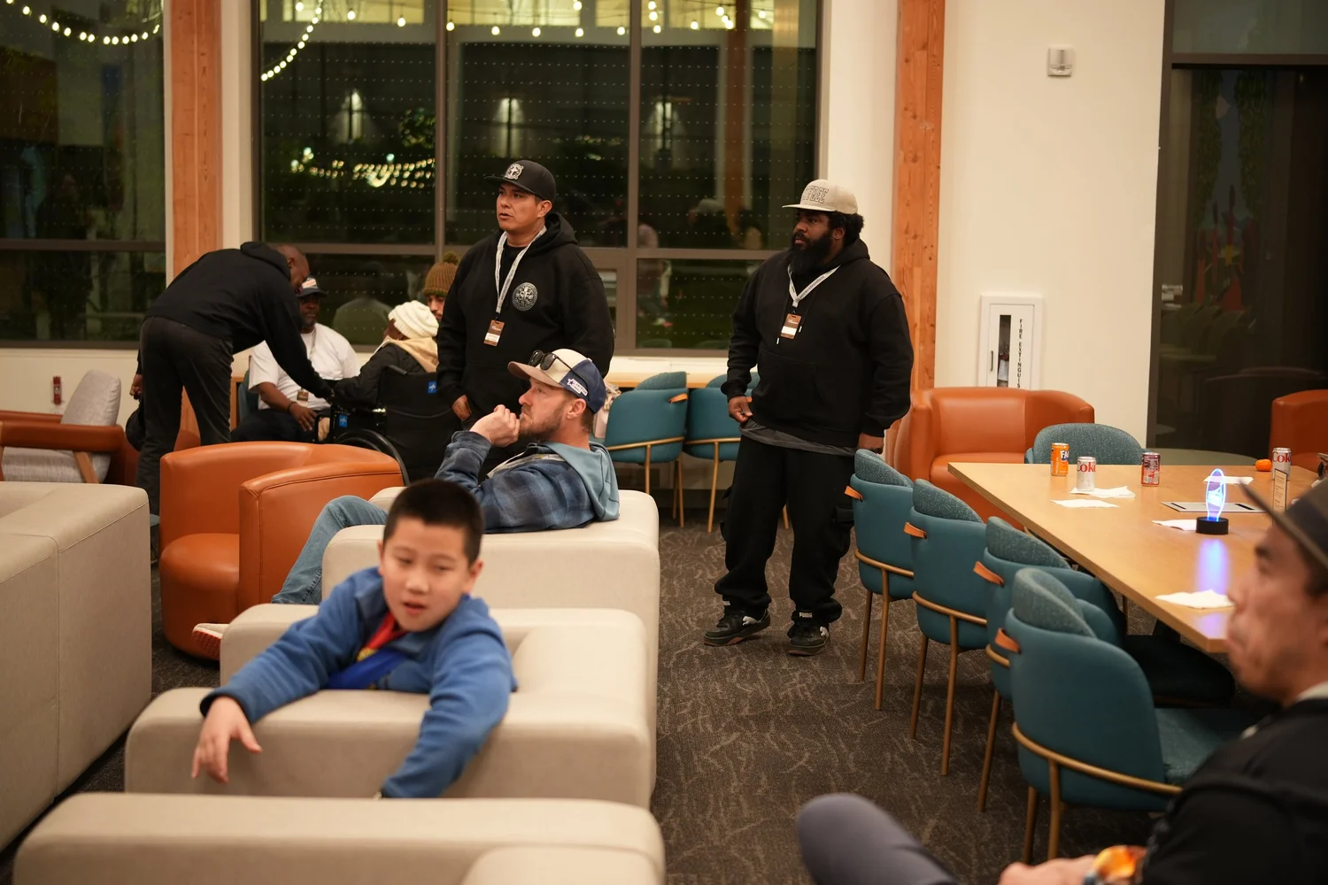 Children and adults gathered around lounge sofas.
