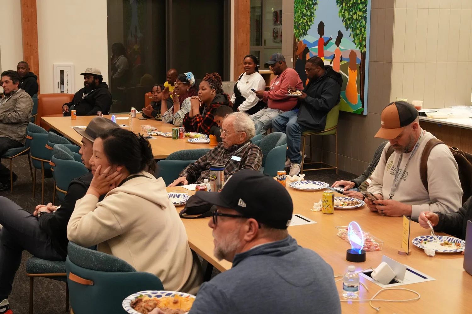 Audience seated closely around tables during the gathering.