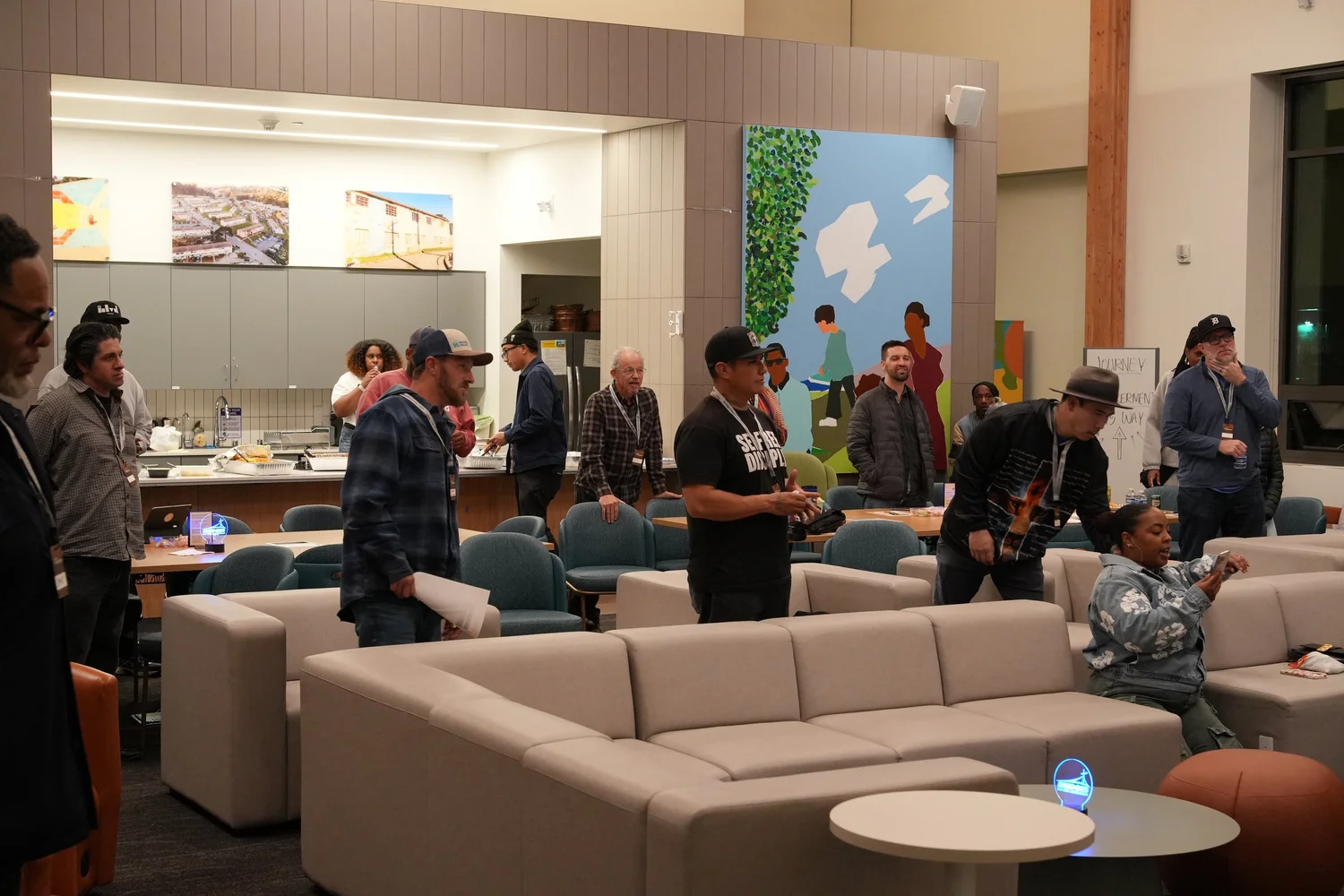 Attendees standing between sofas and tables.
