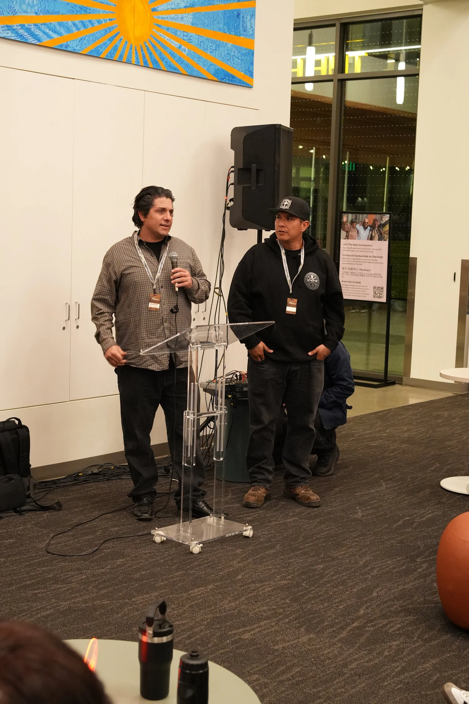 Two speakers standing at the front of the lounge.
